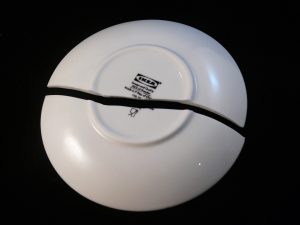 A broken plate shown as a risk of cutting corners when packing
