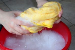 Close up of women ands holding a yellow sponge.