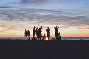People around the campfire on the beach.