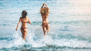 Two girlfriends going for a swim.
