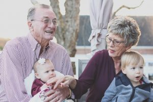 Ways to spend your retirement - old couple holding their grandchildren.