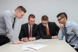 Four men sitting at a desk.