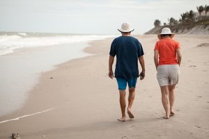 Elderly couple walking on the beach in Florida.