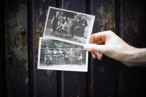 Person holding old photographs.