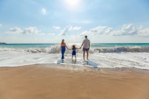 A mother, father and their daughter holding hands on the coast; this family bliss is among the biggest reasons to move to Daytona Beach.