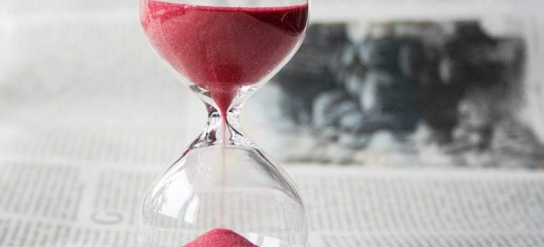 an hourglass with pink sand and the newspaper background
