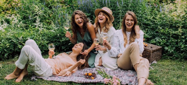 A group of ladies having wine and laughing.