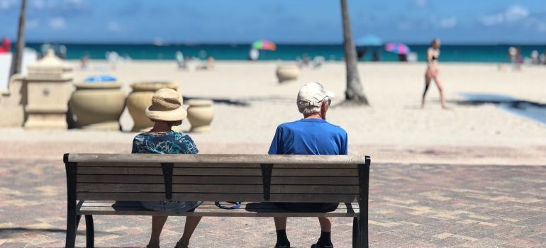 Elder couple sitting on a bench in Miami.