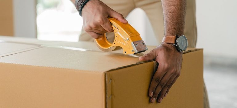 hands taping a box are part of the best movers Gainesville FL