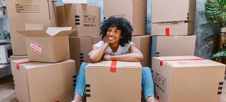 woman sitting on the floor surrounded by boxes