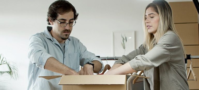 two people packing a box
