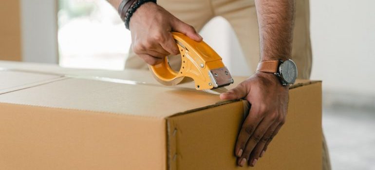 person packing a moving box