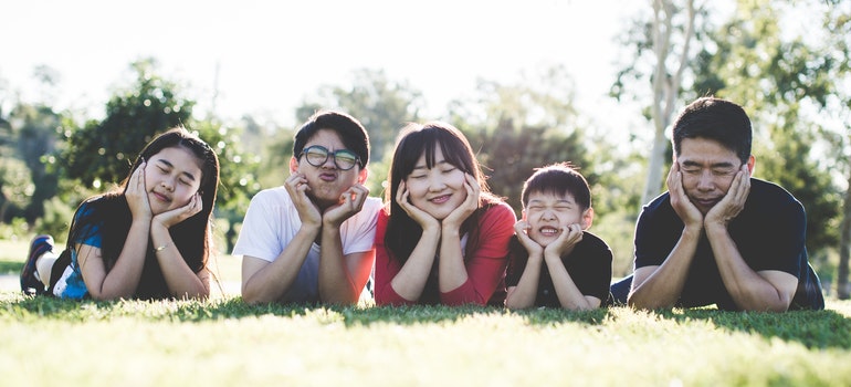 A happy Asian family is lying on the ground.