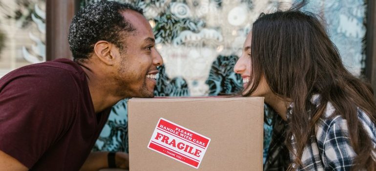 a couple looking at each other over a cardboard box