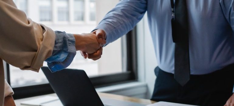 Two persons handshaking in an office.