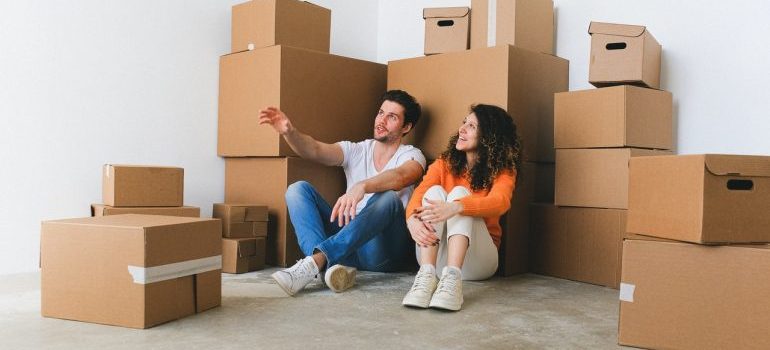 man and woman surrounded by moving boxes planning to hire residential movers Palm Coast FL