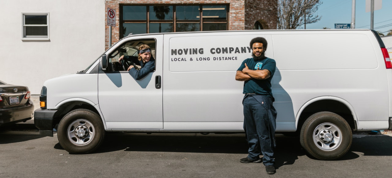a moving crew personnel standing in front of a white van