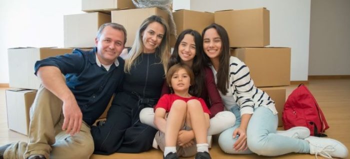 A family surrounded by moving boxes.