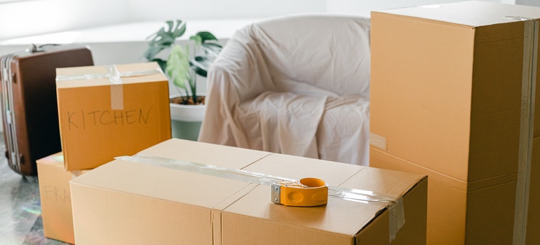 Moving boxes next to a chair.
