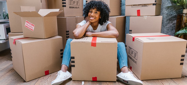 A woman sitting and smiling in between the moving boxes