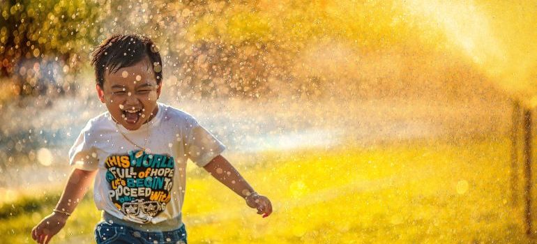 child running through sprinklers
