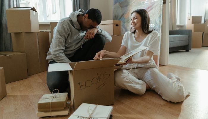 Couple surrounded by boxes, smiling