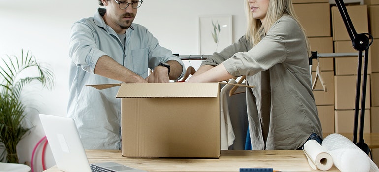 A man and a women are packing things for moving from New York to Miami