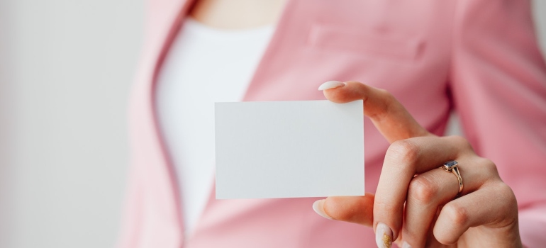 A woman holding a business card